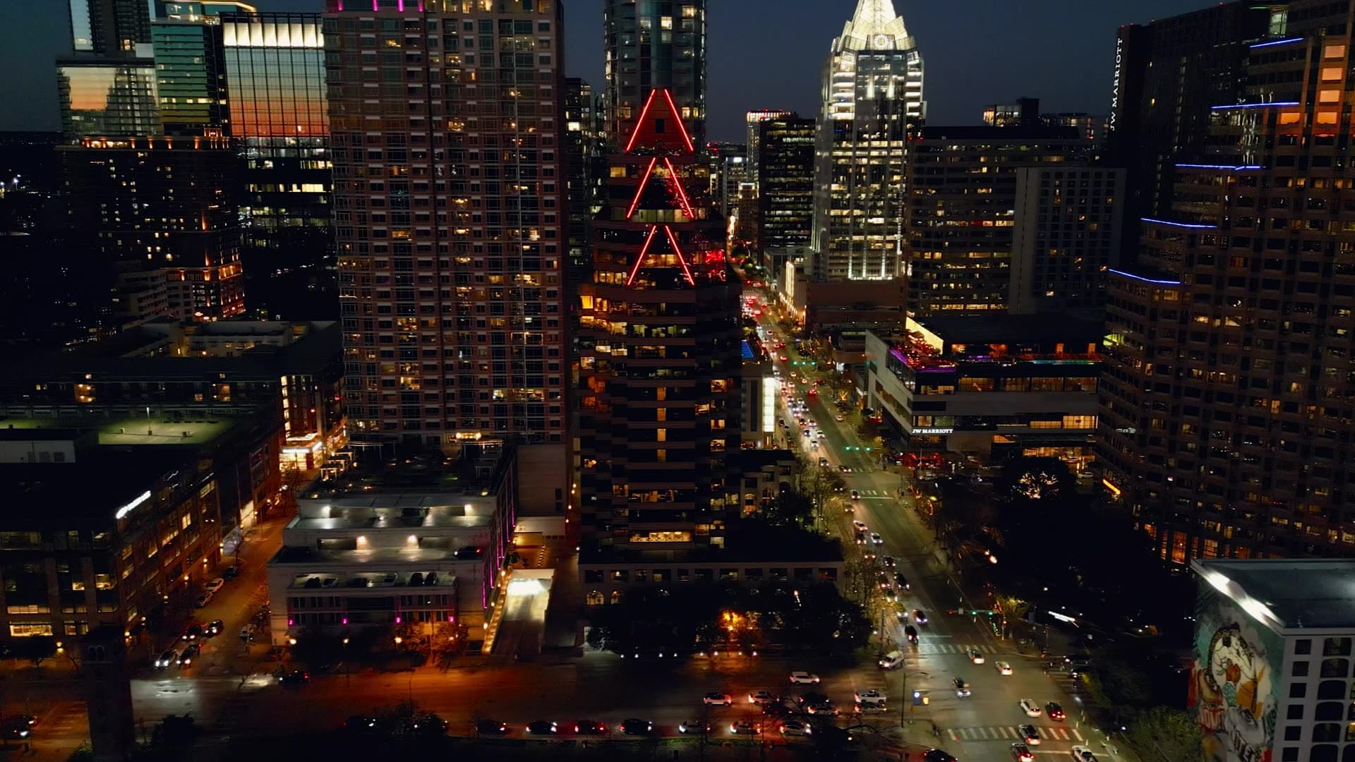 Downtown towers and a busy avenue lit at night